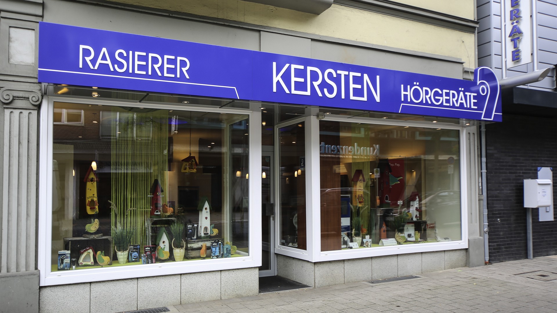 Außenansicht der Hörgeräte Kersten Filiale Neumünster mit modernem Eingangsbereich in zentraler Lage